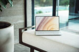 silver laptop on brown wooden table